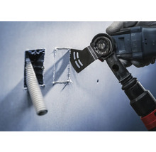 Multifunktionswerkzeug schneidet eine Öffnung in eine Wand für ein Leerrohr