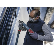 Ein Handwerker benutzt ein Multifunktionswerkzeug zum Schneiden in einer Wand