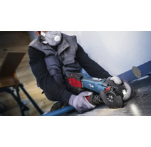 Handwerker verwendet einen Winkelschleifer mit Staubabsaugung auf einem Holzboden