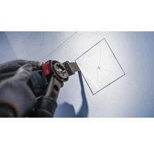 Multifunktionswerkzeug im Einsatz, um eine quadratische Öffnung in eine Oberfläche zu schneiden.