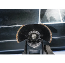 Oszillierendes Elektrowerkzeug schneidet Fugenmasse zwischen Fliesen