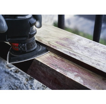 Dreieckschleifer beim Schleifen eines Holzstücks