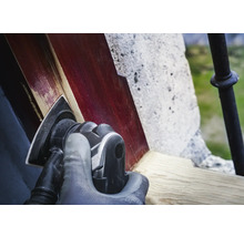 Eine Person schleift Holz mit einem Dreieckschleifer.