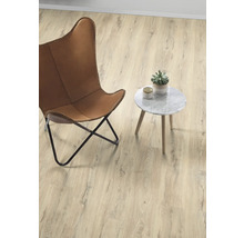 Helles Zimmer mit Sessel, Beistelltisch und Topfpflanze auf Holzboden