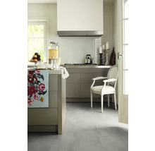 Helle Küche mit Kücheninsel, Dunstabzugshaube, Herd, Armlehnstuhl und Dekorationen.