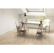 Heller Raum mit Dachfenster, hellem Holzboden, Schreibtisch auf Böcken und Arbeitsmaterialien