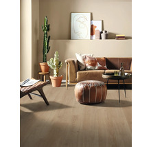 Helles Wohnzimmer mit Sofa, Kissen, Pflanzen und Holzboden