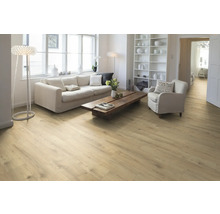 Heller Wohnraum mit Holzboden, Sofa, Sessel und Regal.