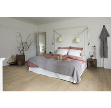 Helles Schlafzimmer mit Doppelbett, Nachttisch und Holzboden