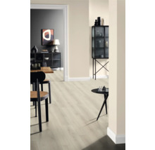 Innenraum mit hellem Laminatboden, Stühlen und Dekorationsgegenständen auf Tischen und in einem Glasschrank.