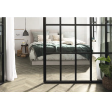 Helles Schlafzimmer mit Bett, Holzfußboden und Raumteiler im Fensterstil