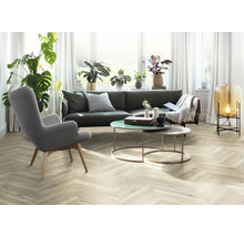 Wohnzimmer mit grauer Couch, Sessel und Dekoartikeln auf dem Tisch