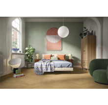 Helles Schlafzimmer mit Bett, Nachttischen, Lampe, Schrank und Sessel