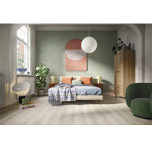 Schlafzimmer mit Bett, Schrank, Sessel und dekorativen Elementen für ein gemütliches Ambiente