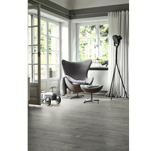 Heller Raum mit modernem Sessel, Stehlampe und grauem Vinylboden in Holzoptik