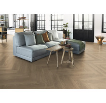 Wohnzimmer mit Parkettboden im Fischgrätmuster, Sofa und Holztischen.