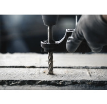 Bohrmaschine mit Bohrer bohrt in Beton