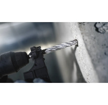 Eine Bohrmaschine bohrt ein Loch in eine Betonwand.