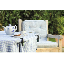 Gedeckter Gartentisch mit Teekanne, Tasse, Kuchen und Tischdeckenklammern auf karierter Tischdecke neben einem Stuhl mit Kissen