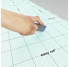 Person schneidet mit einem Cutter Messer eine Schneidunterlage mit Raster