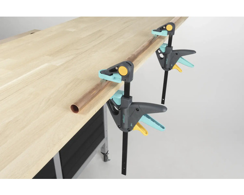 Werkbank mit zwei Wolfcraft Einhandzwingen und einem Kupferrohr.