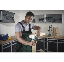 Mann fixiert Holzstücke mit einer Einhandzwinge in einer Werkstatt.