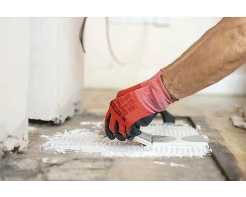 Produktbild 3 (groß) Fliesenleger trägt Klebstoff auf Fliesen auf