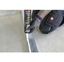 Handwerker trägt Klebstoff auf Metallprofil auf, Fix All Extreme Power Kleber