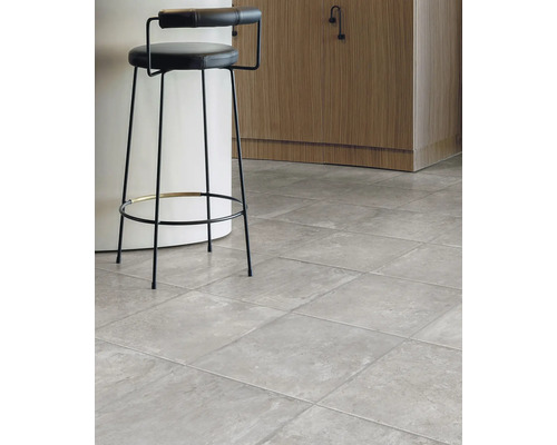 Innenraumansicht mit grauem Fliesenboden und Barhocker