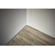 Ecke eines Raumes mit Holzboden und strukturierter Wand