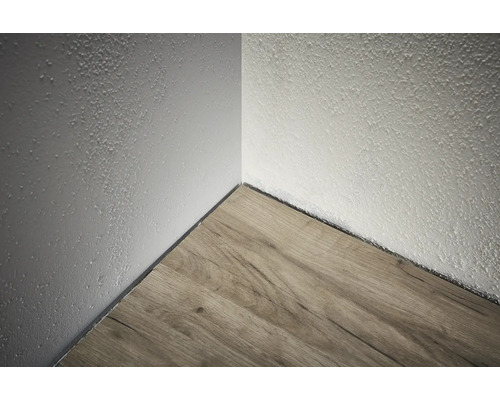 Ecke eines Raumes mit Holzboden und strukturierter Wand