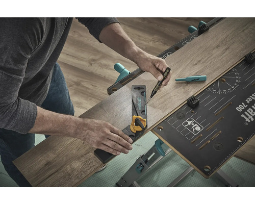 Eine Person benutzt eine Werkbank, einen Winkel und einen Stift, um ein Laminatstück zu bearbeiten.