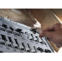 Ein Set aus verschiedenen Fräsern in einer Kunststoffbox, eine Hand hält einen Fräser.