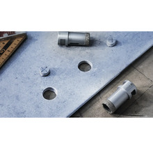 Diamantbohrer und Bohrlöcher in einer Metallplatte mit einem Winkelmesser