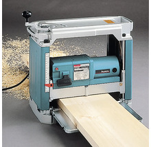 Makita Dickenhobel hobelt ein Holzbrett, mit sichtbaren Holzspänen daneben.