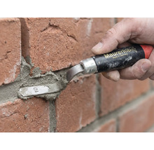 Eine Person nutzt eine Maurerlob Fugenkelle zum Verfugen von roten Ziegelsteinen mit Mörtel.