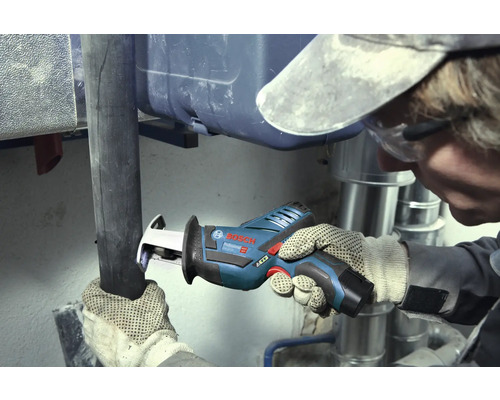 Handwerker schneidet ein dunkles Rohr mit einer Bosch Professional Akku-Säbelsäge in einem Arbeitsbereich mit silbernen Metallrohren.