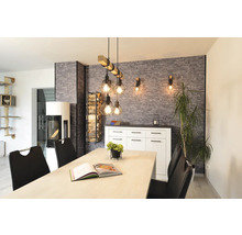 Modernes Esszimmer mit Industrial-Pendelleuchte aus Holz und Metall, Wand in Steinoptik, weißem Sideboard und Kaminofen.