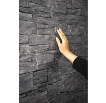 Wandverkleidung in Natursteinoptik mit strukturierter Oberfläche, die von einer Hand berührt wird.