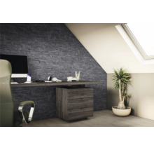 Moderner Arbeitsbereich im Dachgeschoss mit einer Wandgestaltung aus dunkelgrauen Verblendsteinen in Schieferoptik.