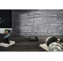 Wandverkleidung in Steinoptik Grau in einem modernen Homeoffice mit Monitor, Smartphone und Kopfhörern auf einem dunklen Holztisch.