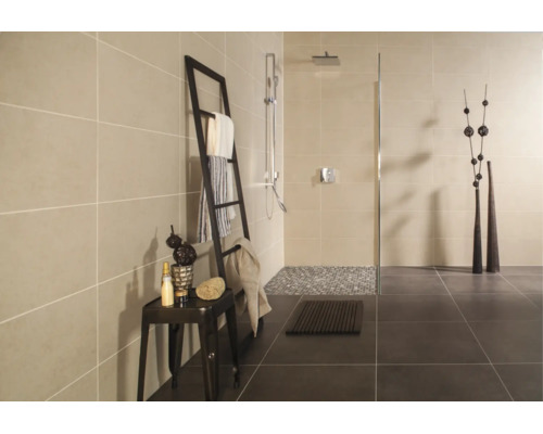 Modernes Badezimmer mit begehbarer Dusche, hellen Wandfliesen, dunklen Bodenfliesen und einer dekorativen Leiter als Handtuchhalter.