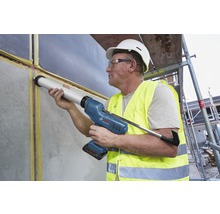 Handwerker verwendet eine Akku-Kartuschenpistole zum Abdichten einer Wand auf einer Baustelle.