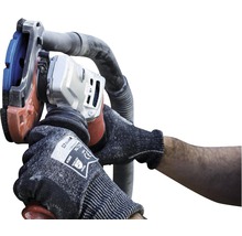 Eine Person verwendet einen Mauernutfräse zum Schneiden von Schlitzen in eine Wand.