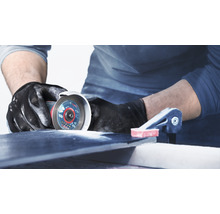 Handwerker schneidet Fliese mit Trennschleifer