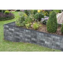 Hochbeet aus grauen Betonsteinen im Garten mit Blumen und Pflanzen