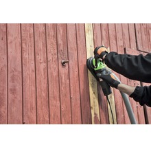 Eine Person schleift eine Holztür mit einem Wandschleifer.