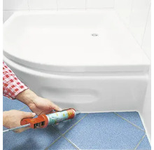 Auftragen von Dichtmasse um eine Duschwanne im Badezimmer.
