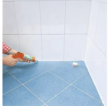 Anwendung von Dichtstoff in einem Badezimmer mit blauen Bodenfliesen und weißen Wandfliesen