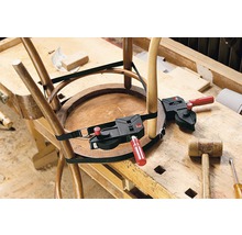 Ein Holzstuhl wird mit einem Umreifungsspanner auf einer Werkbank repariert